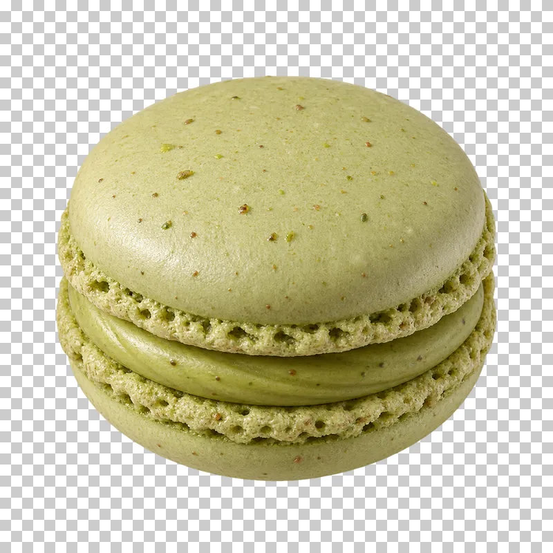 A pale green pistachio macaron with two almond shells, ruffled feet and pistachio cream.