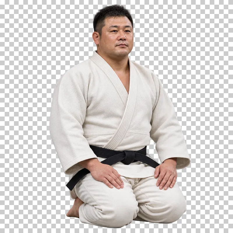 A man in an ivory judogi and black belt kneeling in seiza with his hands on his thighs.