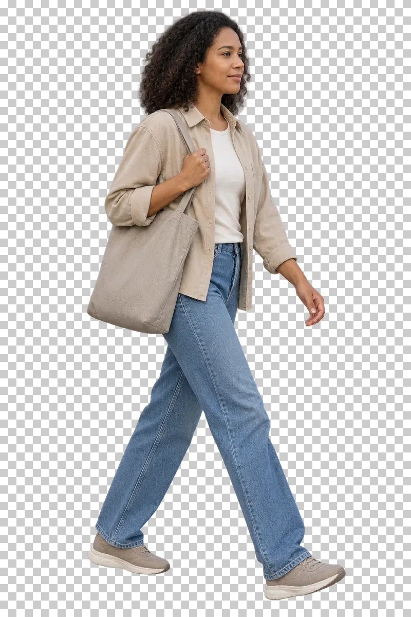 A woman in a beige overshirt and jeans walking with a gray canvas tote.