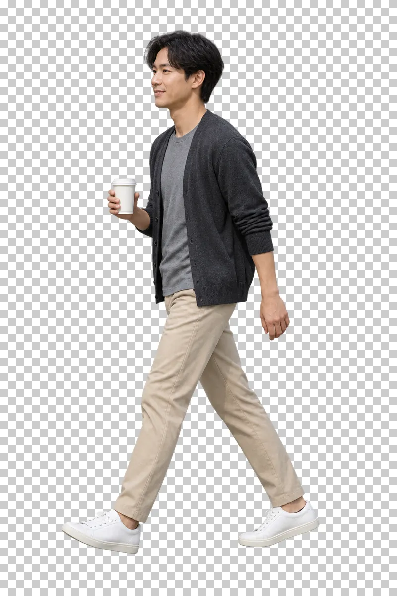 A man in a charcoal cardigan and beige trousers walking with a takeaway coffee.