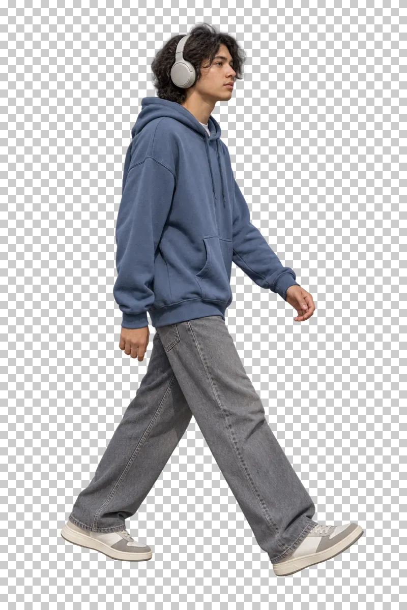 A teenager walking with headphones and casual clothing.