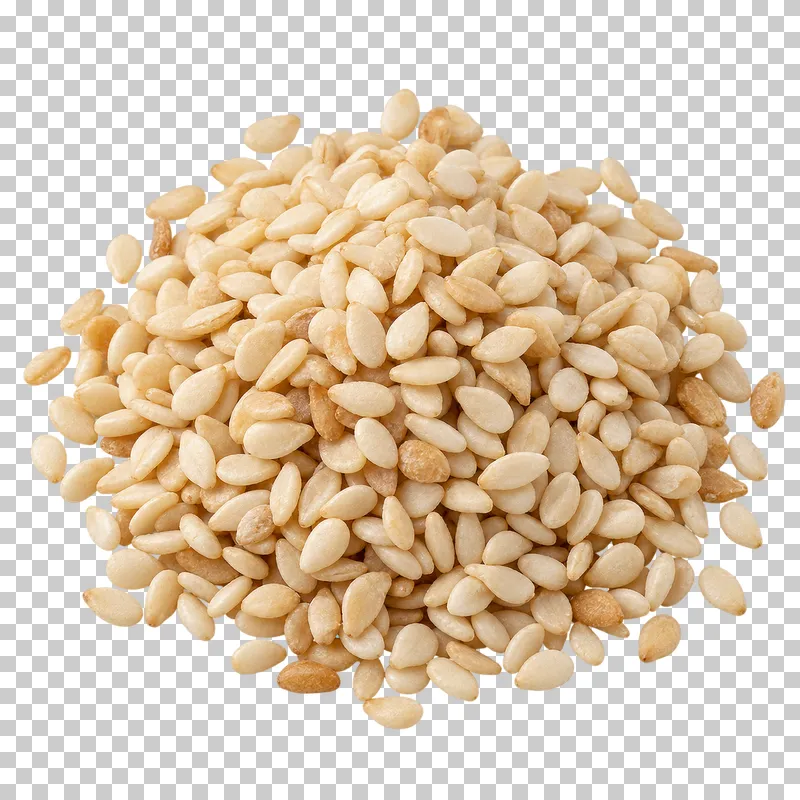 A small mound of sesame seeds with flattened ivory forms and varied orientations.
