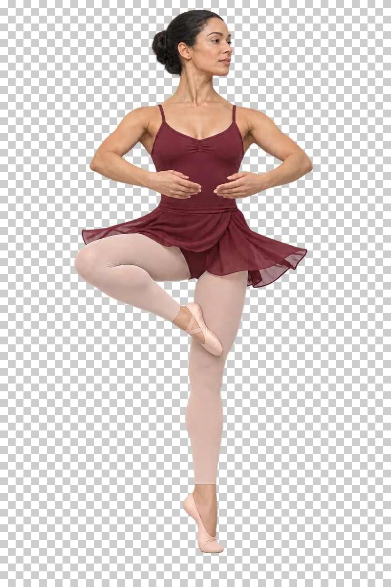 Ballet dancer in a burgundy leotard and rehearsal skirt performing a pirouette on demi-pointe.