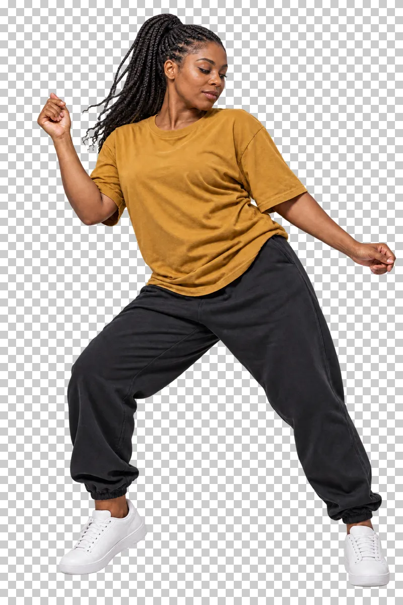 Hip-hop dancer in an ochre T-shirt and black joggers holding a relaxed groove with bent knees.