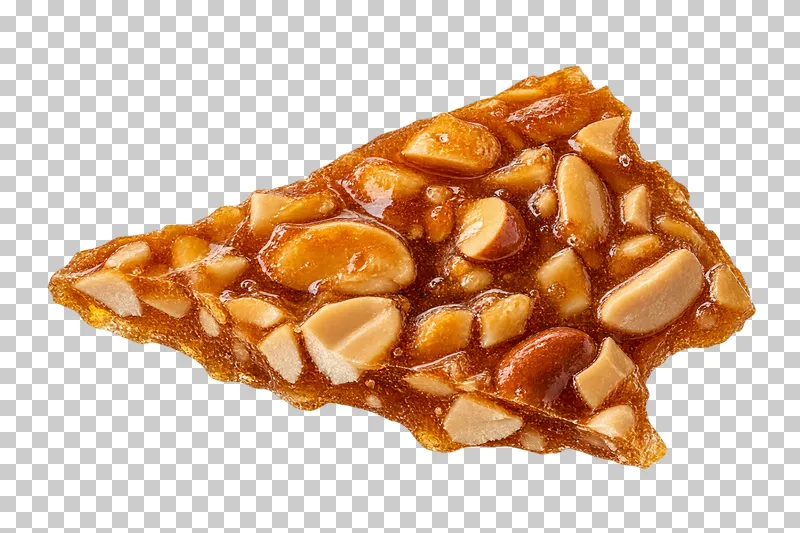 An irregular shard of golden nut brittle with embedded nut pieces and rough caramel edges.