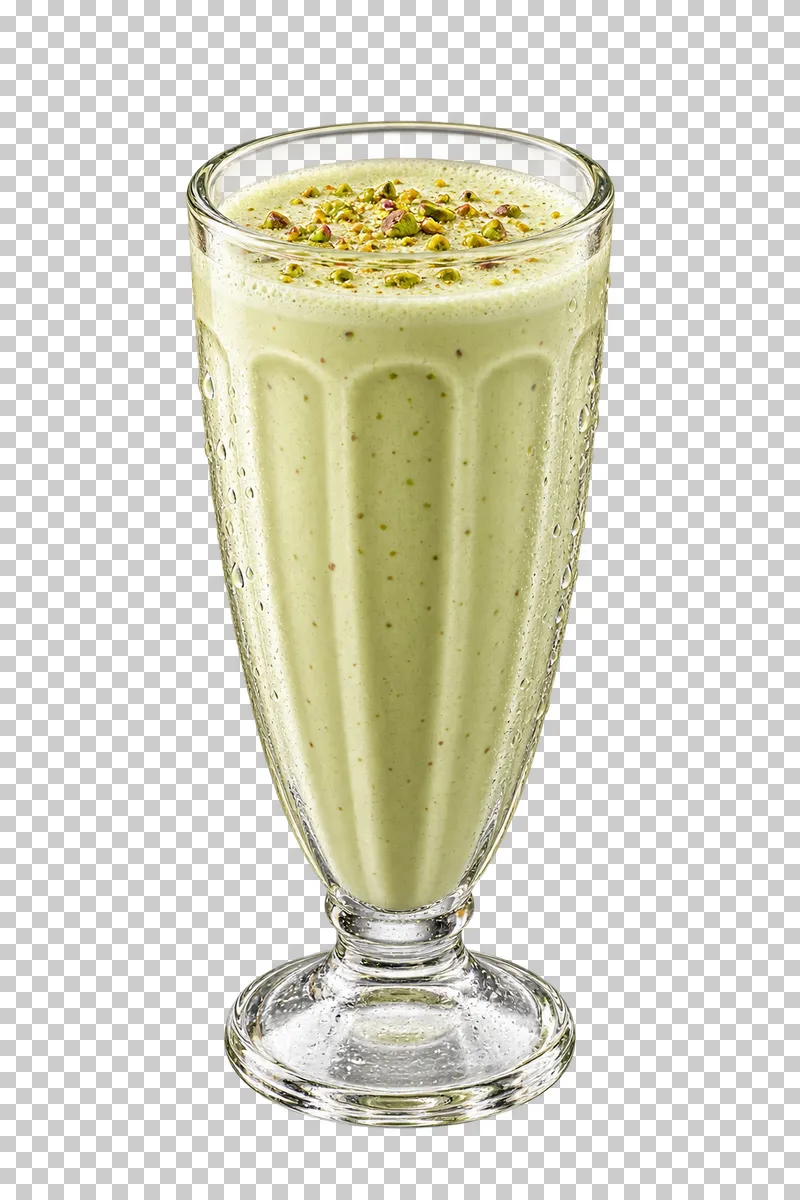 Pale green pistachio milkshake topped with crushed pistachios in a fluted footed glass.