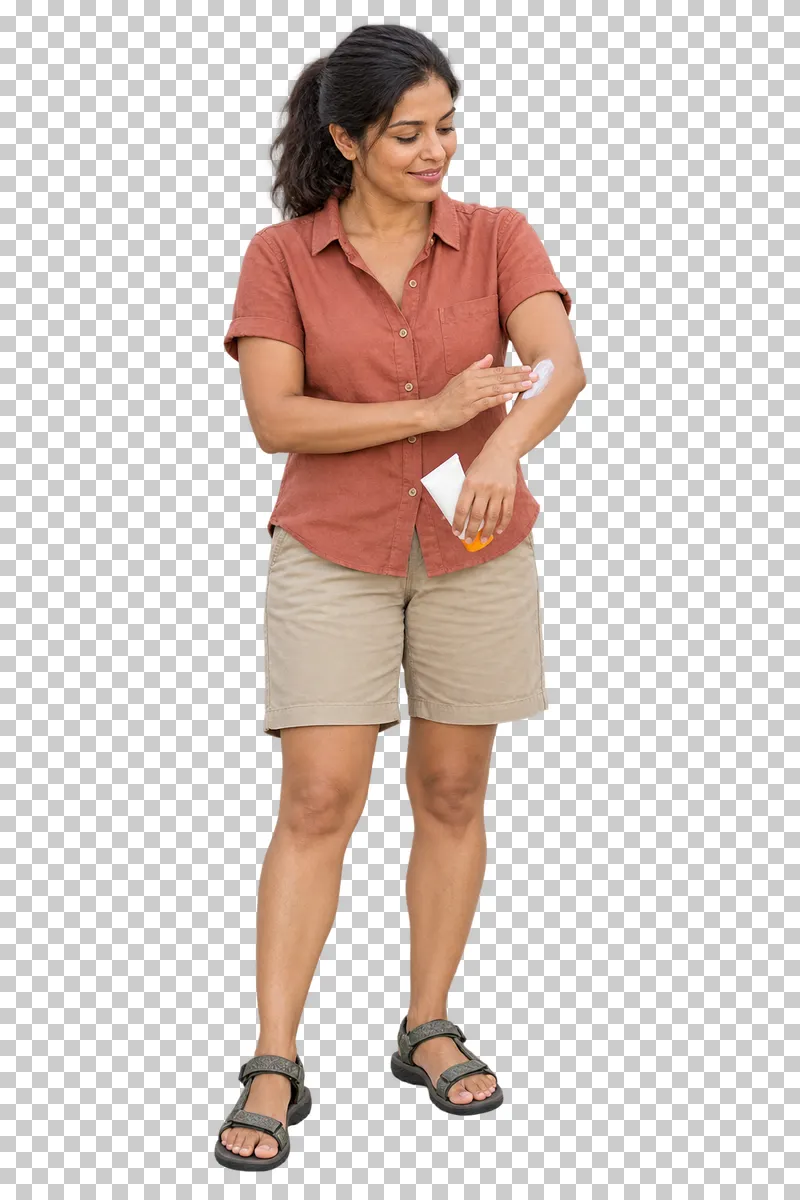 A holidaymaker spreading sunscreen on her forearm while holding a plain tube.