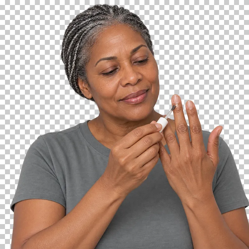 A person applies cuticle oil with a tiny brush at the base of a raised fingernail.