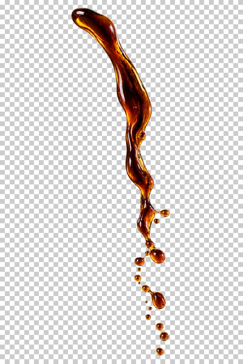 A narrow pouring stream of brewed coffee breaking into droplets.