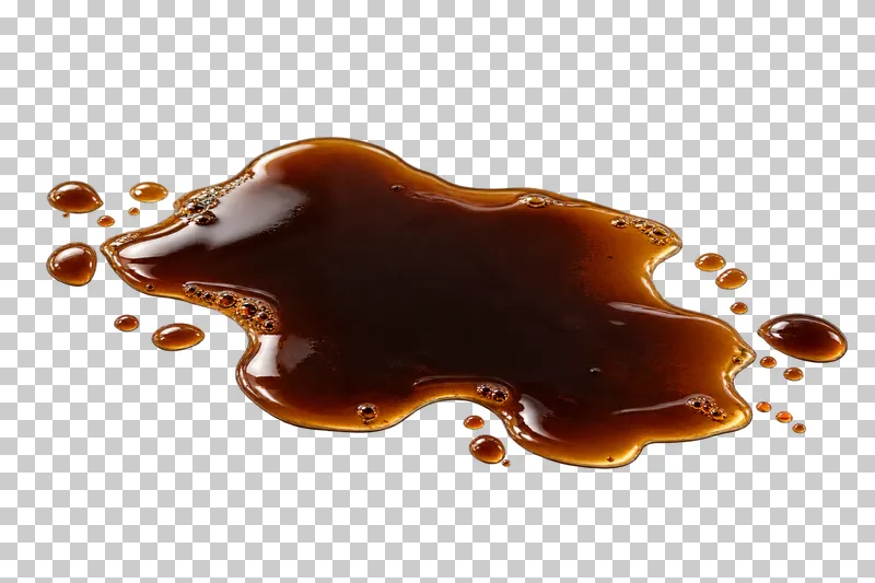 A shallow irregular puddle of spilled brewed coffee with small satellite drops.