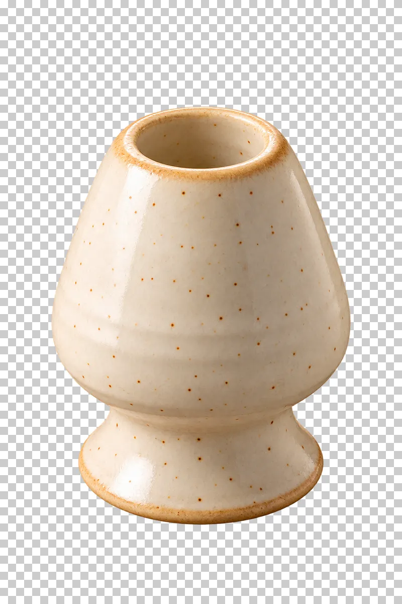 A warm ivory ceramic holder with a hollow top for a matcha whisk.