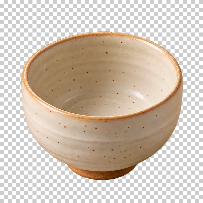 An empty warm ivory speckled ceramic chawan with a brown foot.