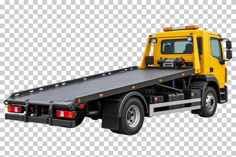 A yellow recovery truck seen from behind with an empty flatbed in travel position.