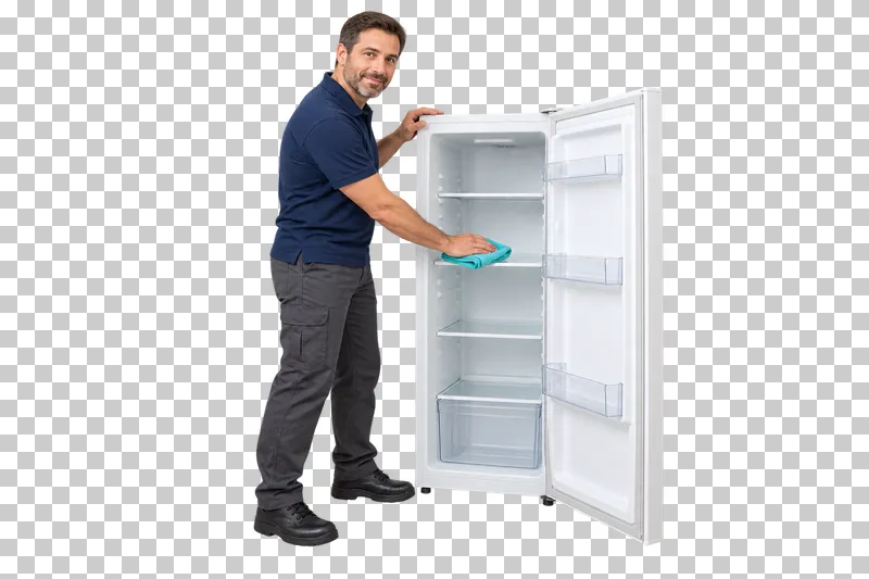 A male cleaner wiping a shelf inside an open white refrigerator.