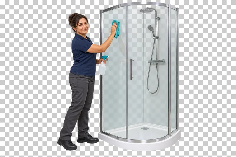A female cleaner wiping the glass of a compact shower enclosure with a white tray.