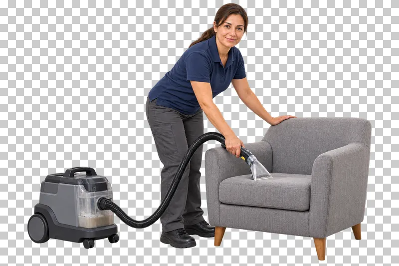 A female cleaner using an upholstery extractor on the seat of a gray armchair.