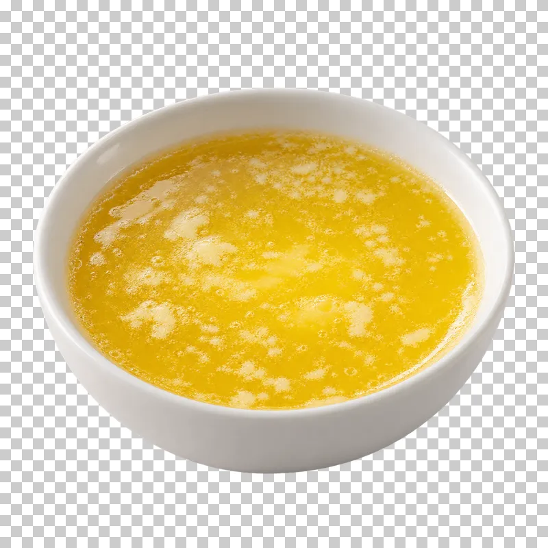 Melted golden butter with milk solids in a white bowl.