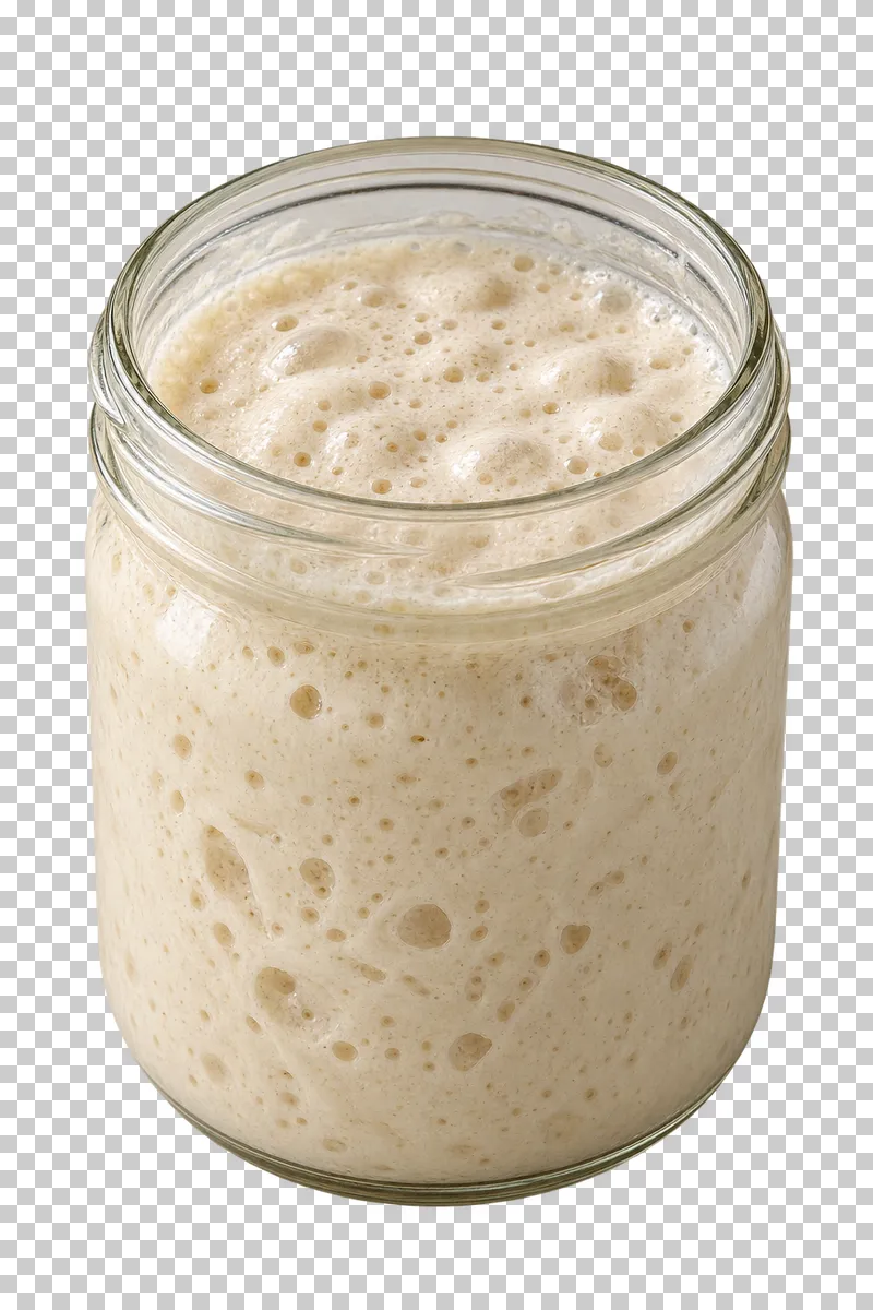 Bubbly active sourdough starter in an open clear glass jar.