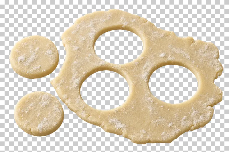A raw cookie dough sheet with three transparent cutout holes and two loose rounds.