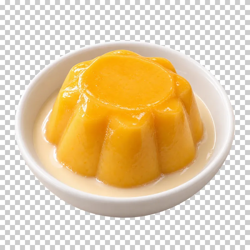 A molded golden mango pudding in a white dessert dish with a pale milk pool.