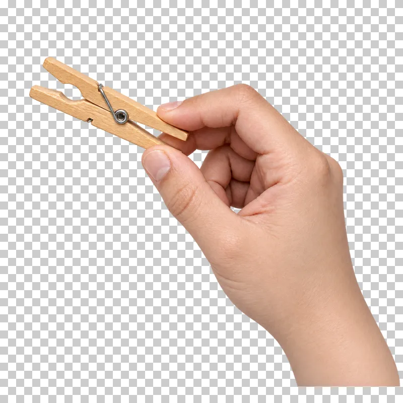 A light hand pinches a wooden spring clothespin with open jaws.