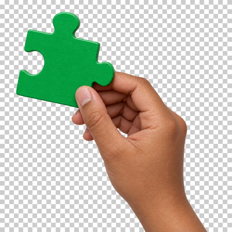 A medium-brown hand positions a green jigsaw piece with tabs and an inward socket.