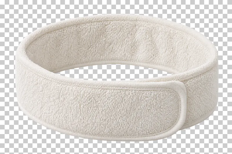 An adjustable ivory terry spa headband with an open center and fastening tab.