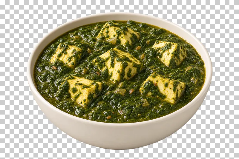 Ivory paneer cubes embedded in a dense finely cooked spinach puree, in a shallow ivory bowl.