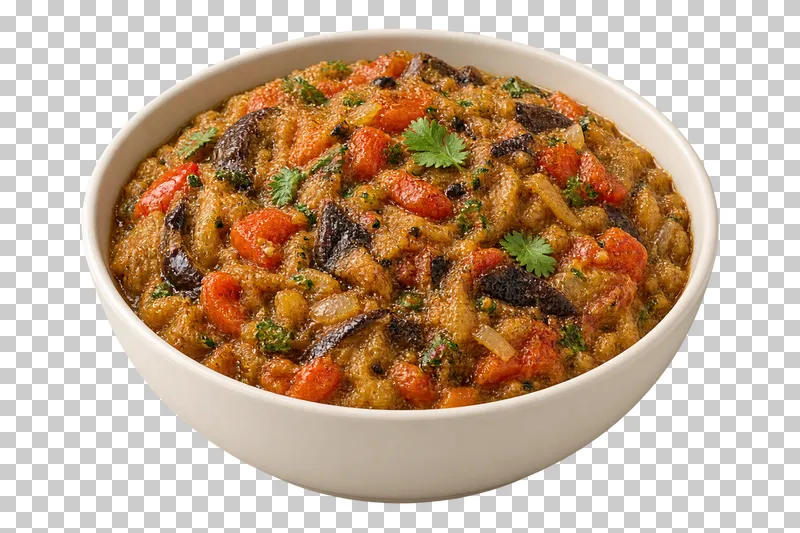 Coarsely mashed roasted eggplant with small tomato and onion pieces and a few herb leaves, in a shallow ivory bowl.