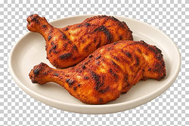 Two bone-in roasted chicken leg quarters with spice coating and dark char marks, on a plain oval ivory plate