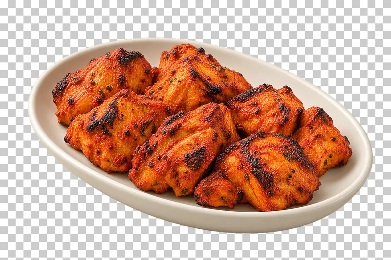 A compact portion of boneless grilled chicken chunks with irregular charred edges, on a plain oval ivory plate